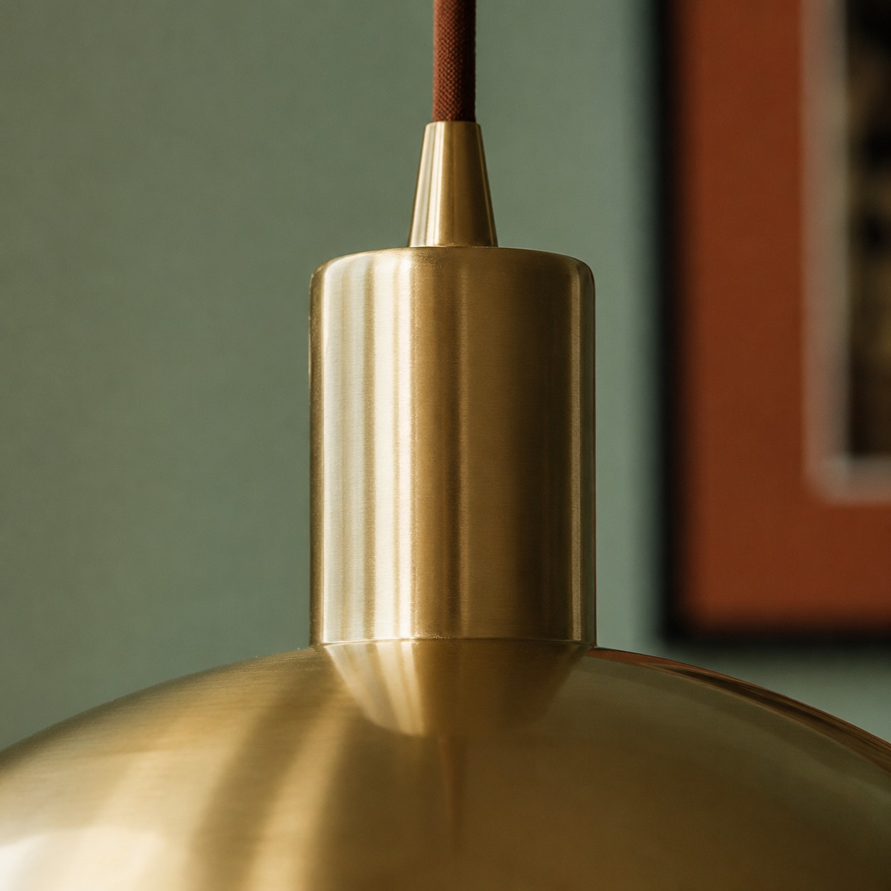 Close view of brass pendant stem and ceiling connection